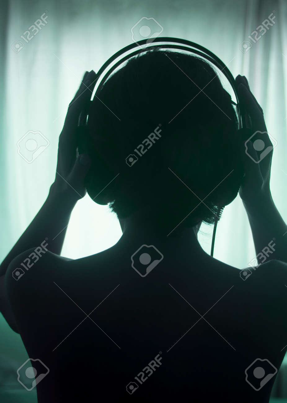 109750132-female-dj-deejay-woman-wearing-closed-headphones-listening-to-music-in-artistic-photo